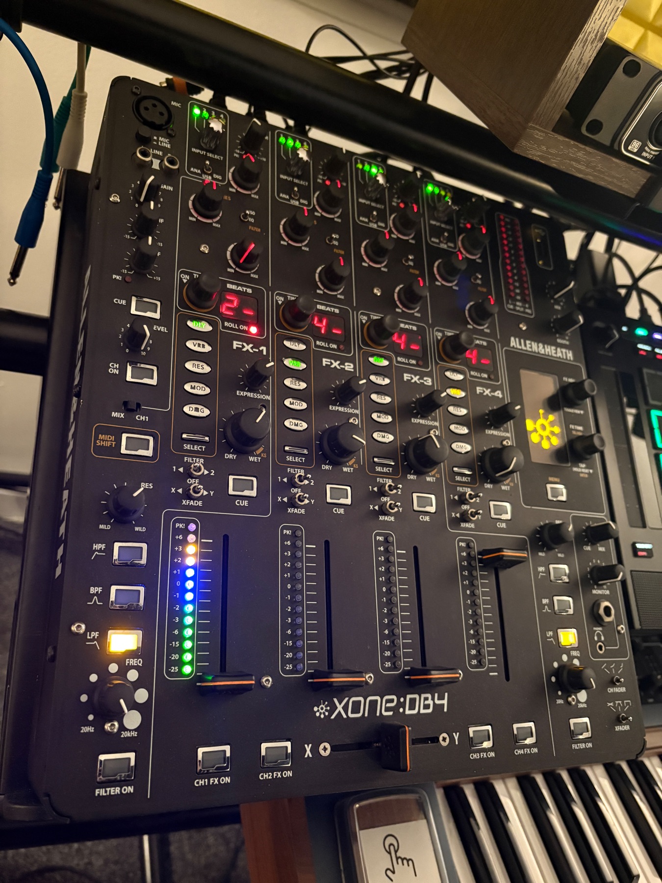 Close-up view of mixer channels and connected audio cables on a Xone DB4.